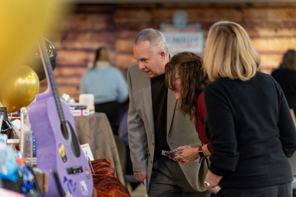 Guests inspect abundant donated silent auction items prior to bidding at the Macomb Community College Foundation’s annual Comedy and Cocktails.